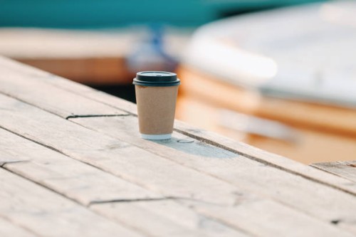 craft paper disposable coffee cup at the wooden pier and riverside background - junk food stock pictures, royalty-free photos & images