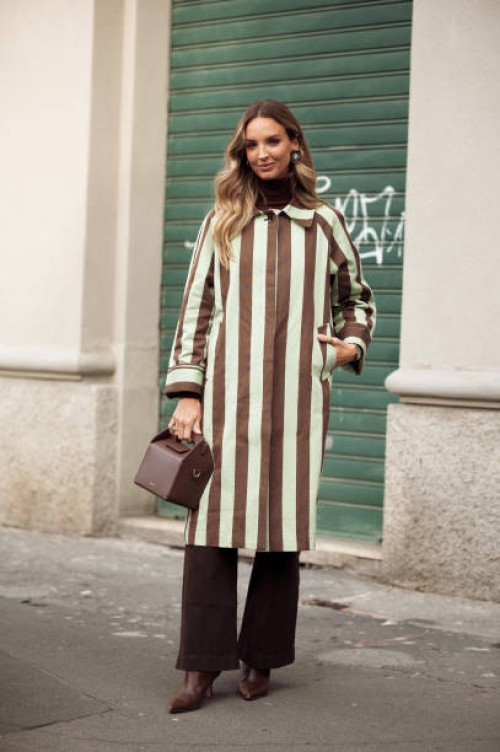 Cris Mata wears mint green and brown stripped coat, dark brown pants, brown shoes and brown bag outside the Vivetta fashion show during the Milan...
