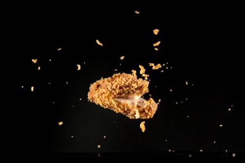 crispy chicken meat flying in mid air captured with high speed sync."n - junk food stock pictures, royalty-free photos & images