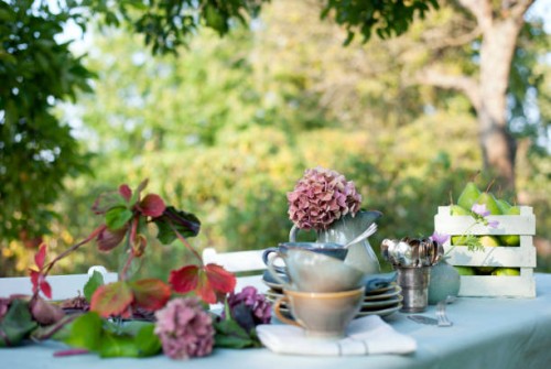crockery, diy lamp shade and jug with blooming hydrangeas lying on coffee table set in garden - garden decoration stock pictures, royalty-free photos & images