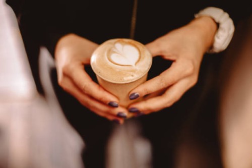 cropped image of female hands holding disposable cup of coffee - junk food stock pictures, royalty-free photos & images