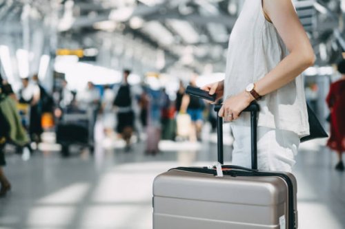 cropped image of young woman holding passport and suitcase walking in the international airport hall - travel stock pictures, royalty-free photos & images