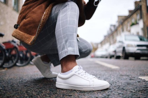 crouching man tying shoelaces on urban road - fashion stock pictures, royalty-free photos & images
