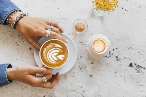 cup of coffee in female hands. cup on white textures stone table surface. - coffee stock pictures, royalty-free photos & images