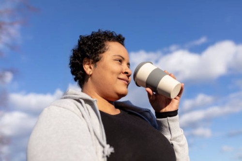 curvy and female student with coffee to go cup in berlin - junk food stock pictures, royalty-free photos & images