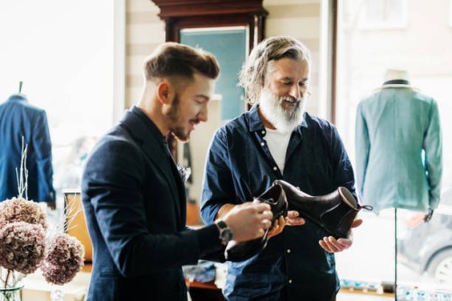 customer looking at shoes in menswear store - fashion stock pictures, royalty-free photos & images