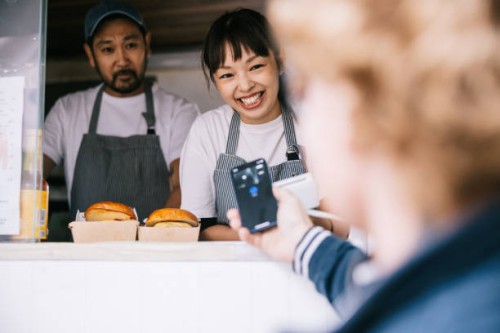 customer making a mobile payment at food truck - junk food stock pictures, royalty-free photos & images