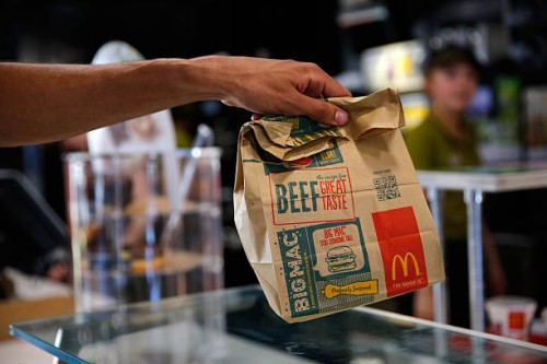 Customer takes a McDonald's Corp. Bag of food inside a McDonald's restaurant in Manchester, U.K., on Monday, Aug. 10, 2015. McDonald's Chief...