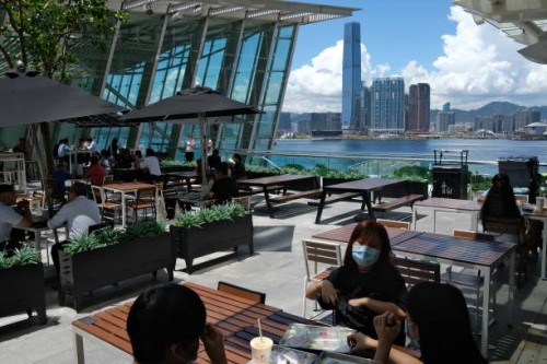 Customers have lunch at an outdoor dining area of a shopping mall in Hong Kong on July 28 a day before new social distancing measures come into...