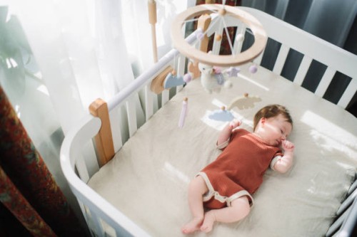 cute baby girl in her crib - home decoration stockfoto's en -beelden