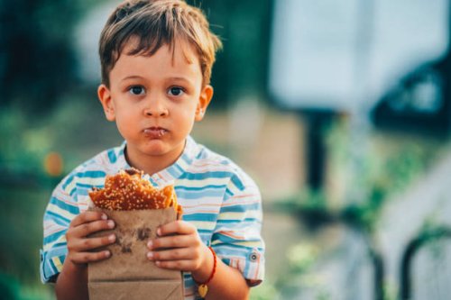 cute boy eating a burger outside - junk food stock pictures, royalty-free photos & images