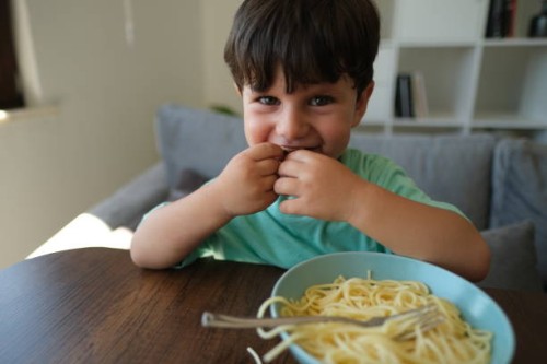 cute child eating spaghetti. - food stock pictures, royalty-free photos & images