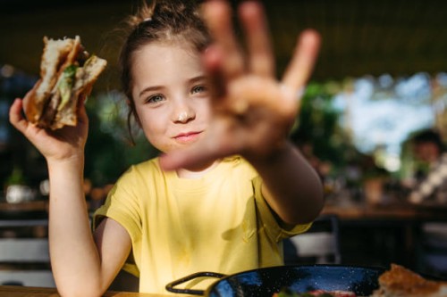 cute girl eating hamburger in restaurant, enjoying quality tasty food. delicious. - food stock pictures, royalty-free photos & images