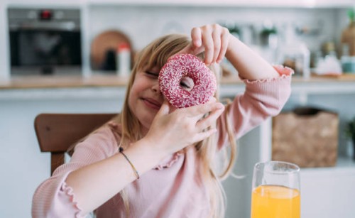 cute little girl looking through donut. - junk food stock pictures, royalty-free photos & images