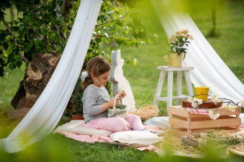 cute little girl on easter egg hunt in blooming spring garden - garden decoration stock pictures, royalty-free photos & images