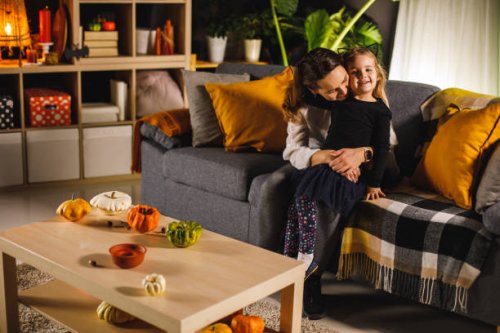 cute little girl smiling at camera while cuddling with her mother - home decoration stock pictures, royalty-free photos & images