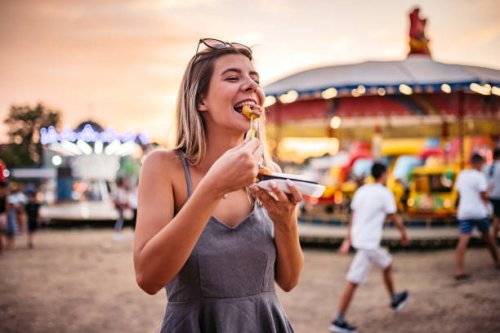 cute woman eating small donuts at the funfair - food stock pictures, royalty-free photos & images