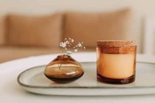 decor elements in the living room of the house a vase with a flower a candle on a glass table beige - home decoration stock pictures, royalty-free photos & images