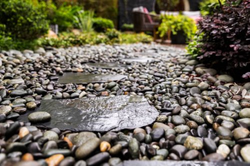 decorative sprinkling of flowerbed paths with pebbles - garden decoration stock pictures, royalty-free photos & images