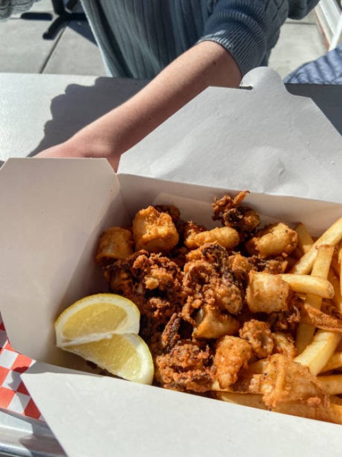 deep fried calamari with fries in paper container - junk food stock pictures, royalty-free photos & images