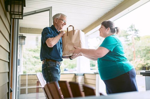 delivering groceries to senior man - food stock pictures, royalty-free photos & images