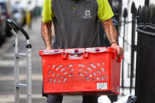 Delivery driver for Ocado Group Plc carries a crate of groceries for delivery to an apartment in London, U.K., on Tuesday, Sept. 29, 2020. Covid-19...