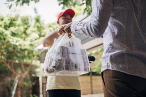 delivery man bringing food - junk food stock pictures, royalty-free photos & images