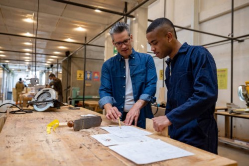 designer explaining to a carpenter his sketch for some furniture - home decoration stockfoto's en -beelden