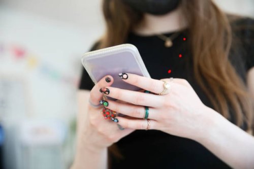detail of a woman's hands using a cell phone, decorated with rings and painted nails of the solar system. - nails art stock pictures, royalty-free photos & images