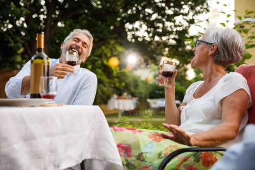 deux amis âgés rient, se lient et dégustent du vin rouge pendant le dîner - garden decoration photos et images de collection