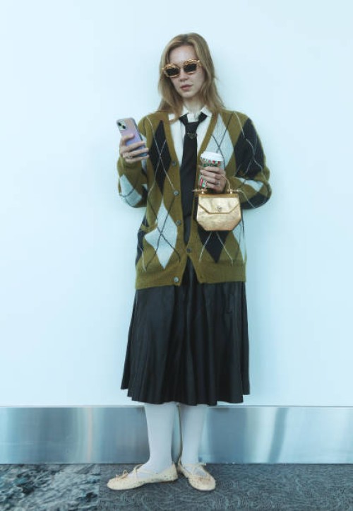 Devyn Ramnarain of Naples, Florida wears a cardigan by Straight to Hell, a shirt by Helmut Lang with a tie by Prada, a faux leather skirt, shoes by...