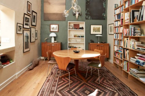 dining table with chairs near bookshelf and frames - home decoration stock-fotos und bilder