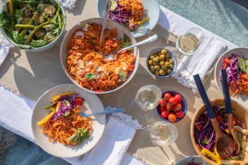 dining table with plates and bowls of food outdoors. - food stock pictures, royalty-free photos & images