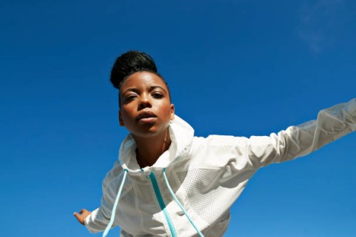 directly below shot of female athlete wearing white jacket against clear blue sky - fashion stock pictures, royalty-free photos & images