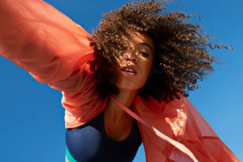 directly below shot of female athlete with curly hair against clear sky - fashion stock pictures, royalty-free photos & images