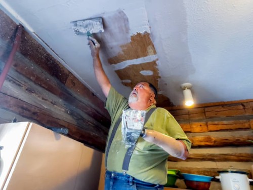 disabled dry wall contractor, patching a ceiling using a drywall tray he made to use with his prosthetic hook - home decoration stock pictures, royalty-free photos & images