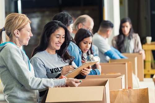 diverse adults packing donation boxes in charity food bank - food stock pictures, royalty-free photos & images