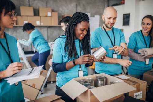 diverse volunteers packing donation boxes in charity food bank - food stock pictures, royalty-free photos & images