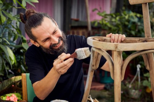 diy in the garden. man painting wooden chair - garden decoration stock pictures, royalty-free photos & images