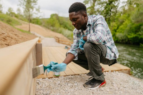 diy: painting a wooden decking next to a river - home decoration stock pictures, royalty-free photos & images