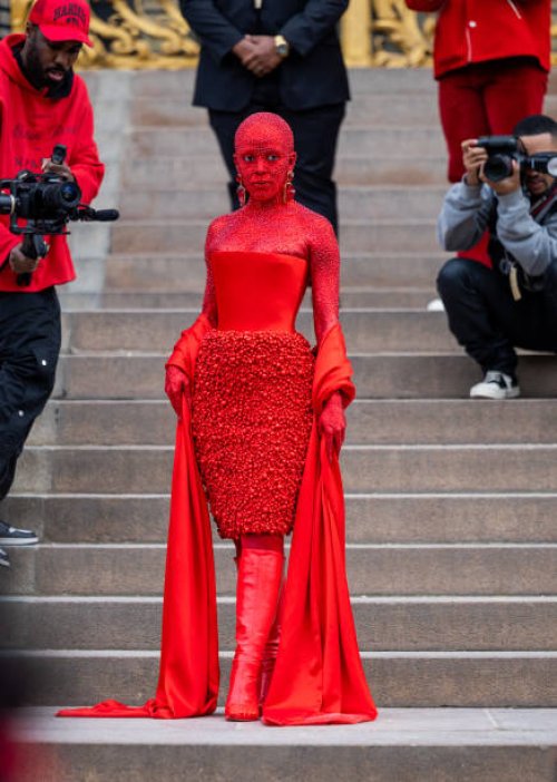 Doja Cat wears red off shoulder dress, red boots outside Schiaparelli during Paris Fashion Week - Haute Couture Spring Summer : Day One on January...
