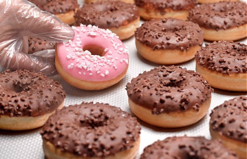 doughnuts chocolate, lifting pink doughnut - junk food stockfoto's en -beelden