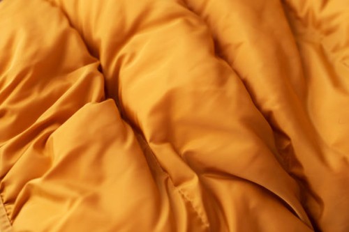 down jacket fabric background, orange puffer jacket texture - fashion stock pictures, royalty-free photos & images
