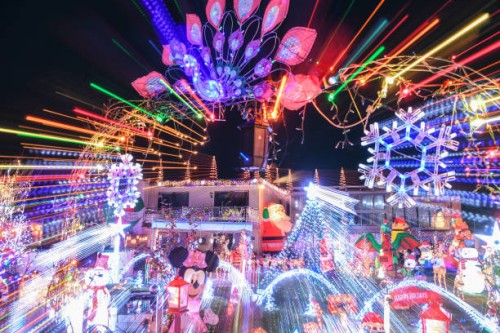 Dozens of illuminated Christmas figures and motives, as well as thousands of lights fill the front garden of a house while music completes the...