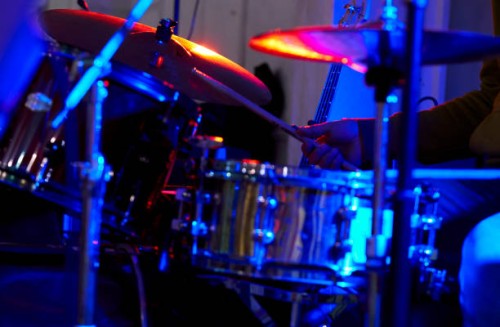 drummer is playing drums in a dimly lit background during a rock concert. - concert stock pictures, royalty-free photos & images