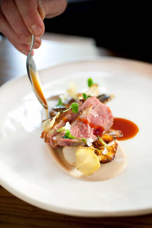 duck breast being drizzled with sauce - food stock pictures, royalty-free photos & images