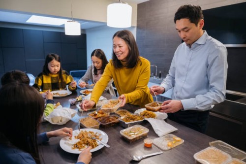 east asian family enjoying takeout food for dinner - junk food stock pictures, royalty-free photos & images