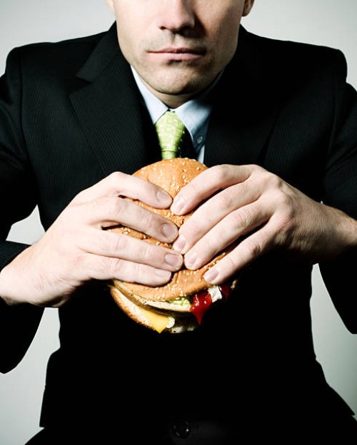 eating at the office - junk food stockfoto's en -beelden