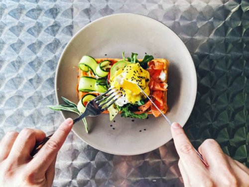 eating brunch with waffle, avocado, cucumber, salmon and poached egg, personal perspective - food stock pictures, royalty-free photos & images