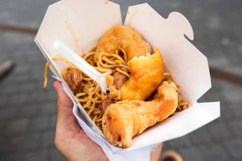 eating chinese food from takeaway box on the street, personal perspective - junk food stock pictures, royalty-free photos & images